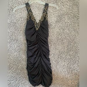 Black bodycon dress with gold beads.